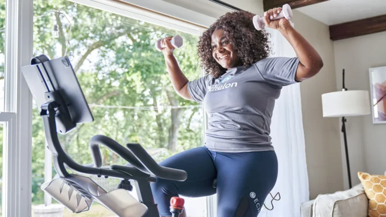 a smiling woman working out on Echelon fitness equipment