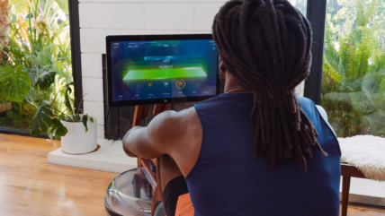 man plays a game while rowing on an Ergatta