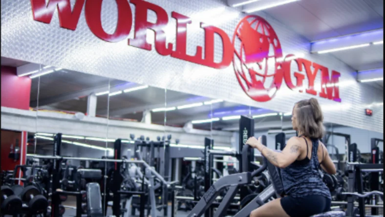 A woman strength training inside a World Gym.