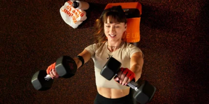 woman working out with dumbbells at Orangetheory Fitness