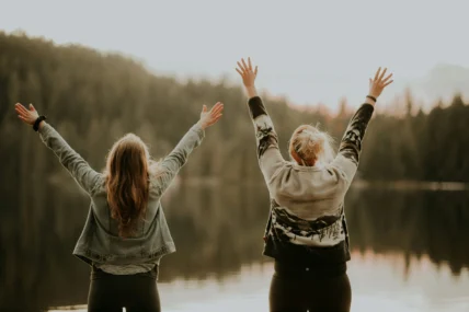 women in front of a lake