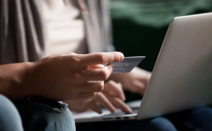 man enters his credit card info on a laptop