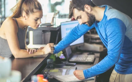 man and woman sign a gym membership contract