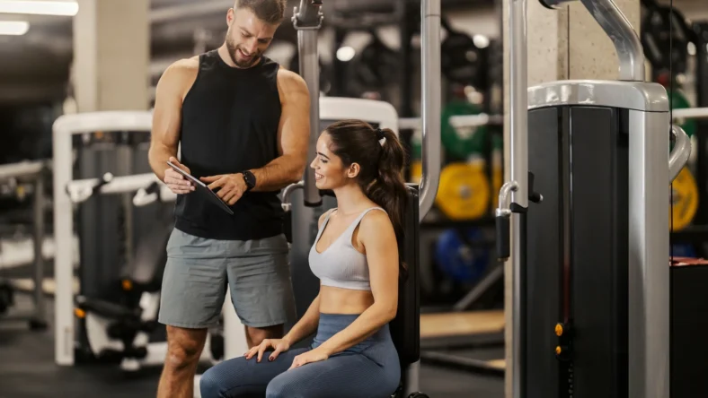 male personal trainer speaks to a female client