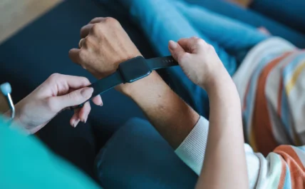 woman places a wearable smartwatch on someone's wrist