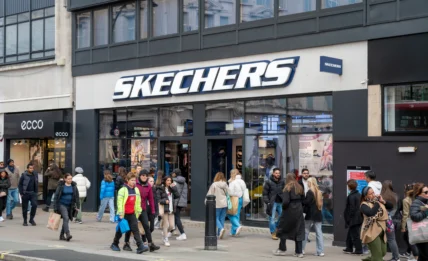 The exterior of a Skechers store with people milling about outside and in front of the store.