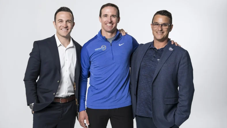 Drew Brees poses with Stretch Zone's Tony Zaccario and Jorden Gold