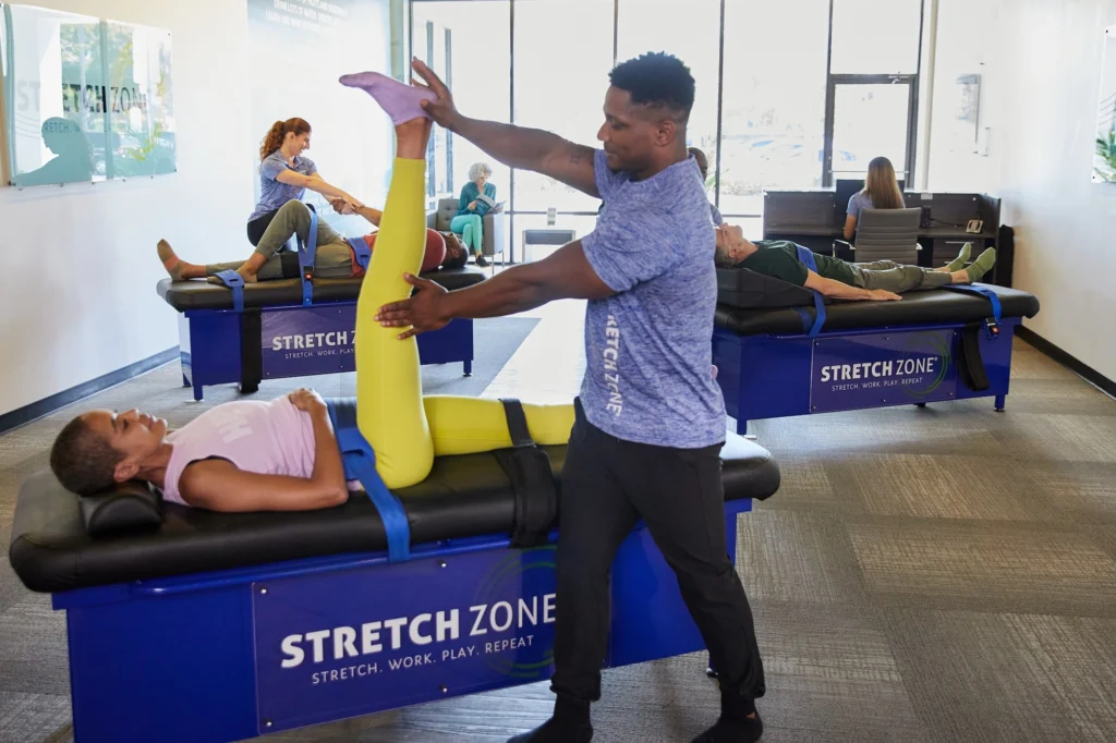 man stretches a woman inside a Stretch Zone location