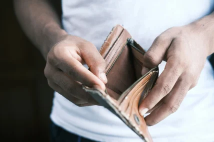 a man looking inside of an empty wallet